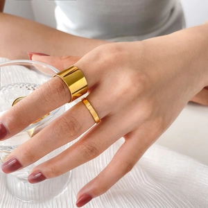 Minimalist wide and thin gold stacking rings set on hand with polished mirror finish