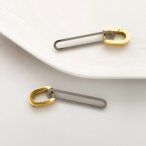 Detail of geometric U-shaped mixed metal earrings in matte gold and silver finish