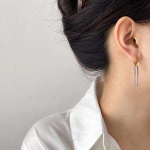 Minimalist geometric U-shape gold and silver two-tone earrings shown on model