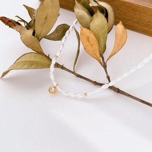 Collier de perles élégant avec billes dorées et pendentif étincelant en zircon
