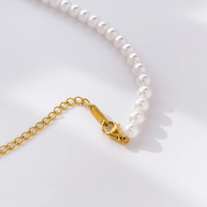 Détail du fermoir mousqueton doré et de la chaîne d'extension du collier de perles