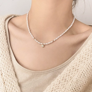 Détail du collier de perles irrégulières avec perles dorées et pendentif zircon