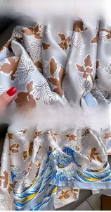 Detail of maple leaf silk scarf showing fine overlock stitching and wave print edge