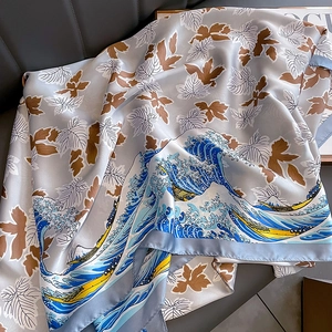 Elegant silver-grey silk scarf with Great Wave and maple leaf prints on leather background