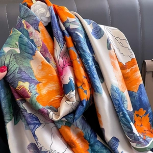 Close-up of a floral silk shawl featuring vibrant orange and purple abstract prints