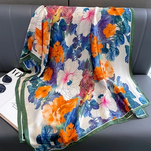 Floral print silk satin scarf with orange and purple petals on dark green border
