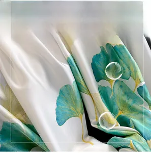 Détail macro du tissu soyeux avec imprimé de feuilles de ginkgo et texture lisse
