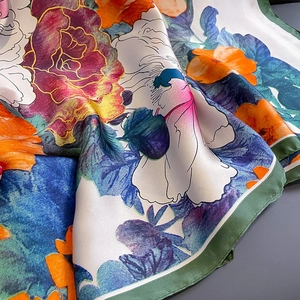 Detailed macro view of floral print silk scarf with satin finish and rolled edges