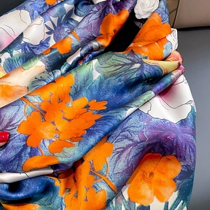 Detail of silk satin scarf with vibrant orange, blue and purple abstract floral print