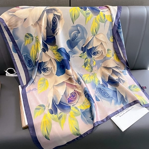 Elegant floral silk scarf with large blue roses and purple hem on grey leather background