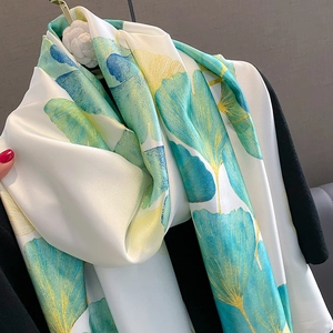 Détail d'un foulard en soie synthétique avec imprimé ginkgo et texture douce légère