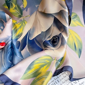 Detail of silk scarf showing vintage blue rose prints and premium satin-finished edges
