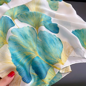Détail macro d'un foulard en soie avec imprimé ginkgo et texture délicate du tissu