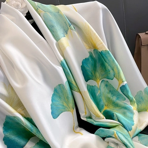 Gros plan d'un foulard en soie élégant avec motif ginkgo vert et finition satinée