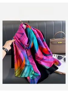 Detailed texture of vibrant rainbow gradient silk scarf draped over a leather bag