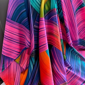 Macro view of colorful abstract striped fabric with vibrant silk-like texture and drape