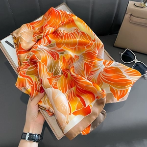 Élégant foulard en soie orange avec imprimé floral et bordure marron en décor lifestyle