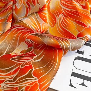 Détail d'un foulard en soie brillant avec des motifs floraux et une texture élégante