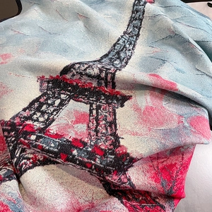 Close-up of jacquard woven scarf with Eiffel Tower pattern in blue and magenta