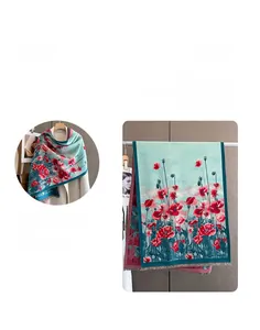 Dettaglio di una morbida sciarpa in simil cashmere con base blu e stampa floreale rossa