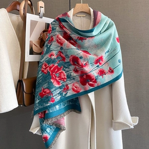 Elegante sciarpa in cashmere con stampa di papaveri e nappe su un cappotto bianco