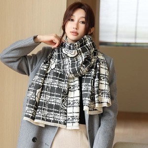 Close-up of black and white reversible cashmere scarf with floral patterns and fringe