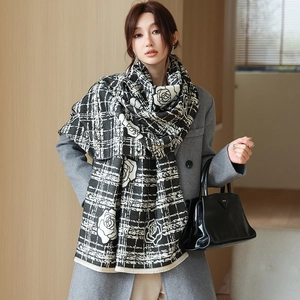 Close-up of black and white floral plaid scarf showing thick texture and tassel fringe