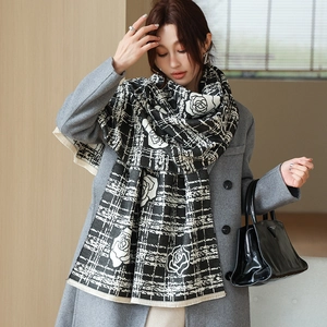 Detail of winter scarf with rose patterns, checkerboard design and tassel edges