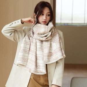 Detail of warm camellia pattern scarf featuring fringe edges and beige plaid texture