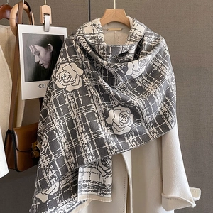 Detail of winter cashmere-like scarf with grey checks and rose pattern over a wool coat