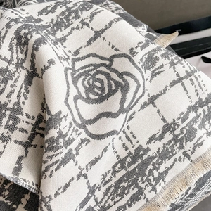 Close-up of camellia jacquard pattern and fringe edge on a thick winter cashmere shawl