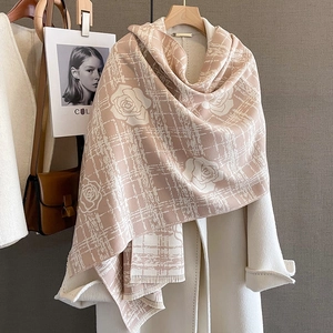Detail of soft camellia pattern scarf with fringe, layered on a white wool coat