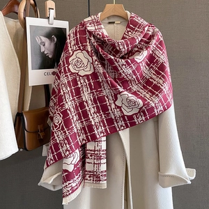 Close-up of red camellia flower cashmere shawl with thick tweed texture and soft tassels