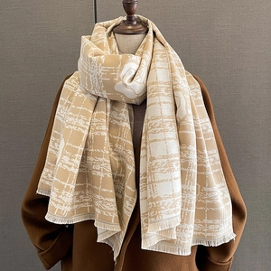 Detail of winter scarf with grid and floral patterns featuring delicate fringe edges