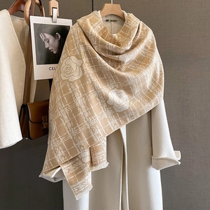 Beige cashmere-like scarf with white camellia pattern and fringe on a wool coat