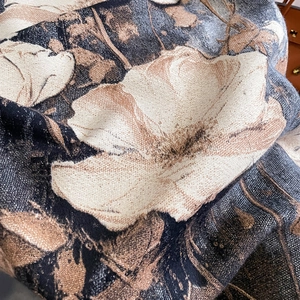 Close-up of floral jacquard knit texture on soft winter pashmina shawl in beige and navy