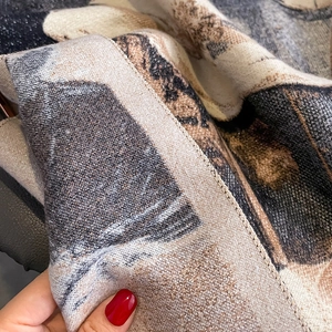 Close-up of thick cashmere-like scarf showing soft texture and artistic jacquard patterns
