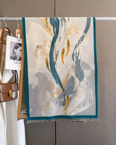 Detail of artistic print scarf with blue and yellow hues and delicate fringe tassels