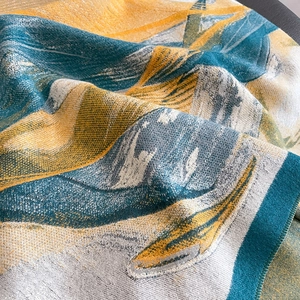 Detailed macro view of abstract jacquard woven scarf in green and mustard yellow