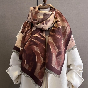 Détail d'une écharpe en cachemire doux à motifs marbrés marron et petites franges