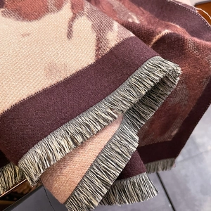 Gros plan sur l'écharpe en maille jacquard motif cheval rétro avec détails de franges