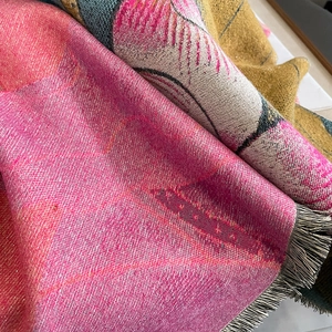 Detailansicht von Pashmina-Schal mit buntem Jacquard-Muster und feinen Fransen am Saum