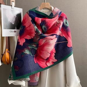 Winter faux cashmere scarf with red poppy print and tassel detail on a white coat