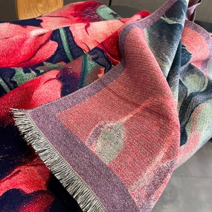 Close-up of floral cashmere feel scarf with metallic thread detail and soft grey fringes