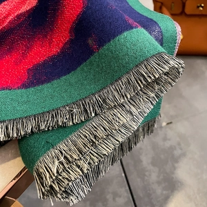 Detailed macro shot of a thick cashmere-style shawl with metallic fibers and tassels