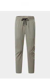 Dettaglio dei pantaloni sportivi da uomo verde oliva chiaro con coulisse in vita