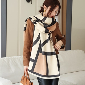 Detailed view of thick geometric cashmere-feel scarf with tassels and tricolor拼接 design