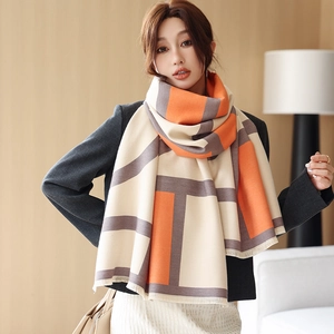 Detailed view of soft cashmere-like scarf featuring geometric color blocking and tassel edges