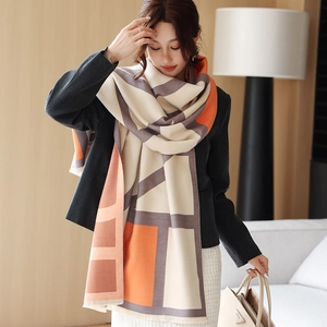 Detail of soft geometric cashmere-like shawl with fringed edges and warm color blocking