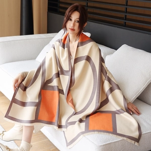 Detail of geometric thick shawl with tassel edge in orange and grey cashmere feel
